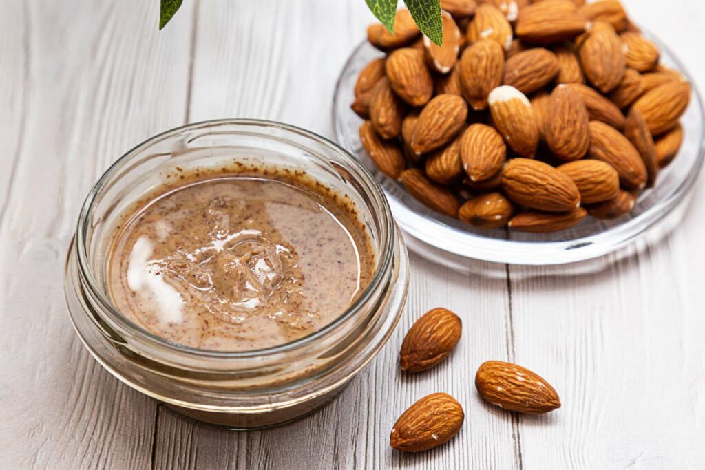 jar-of-almond-butter-bunch-of-fresh-almond-on-whi